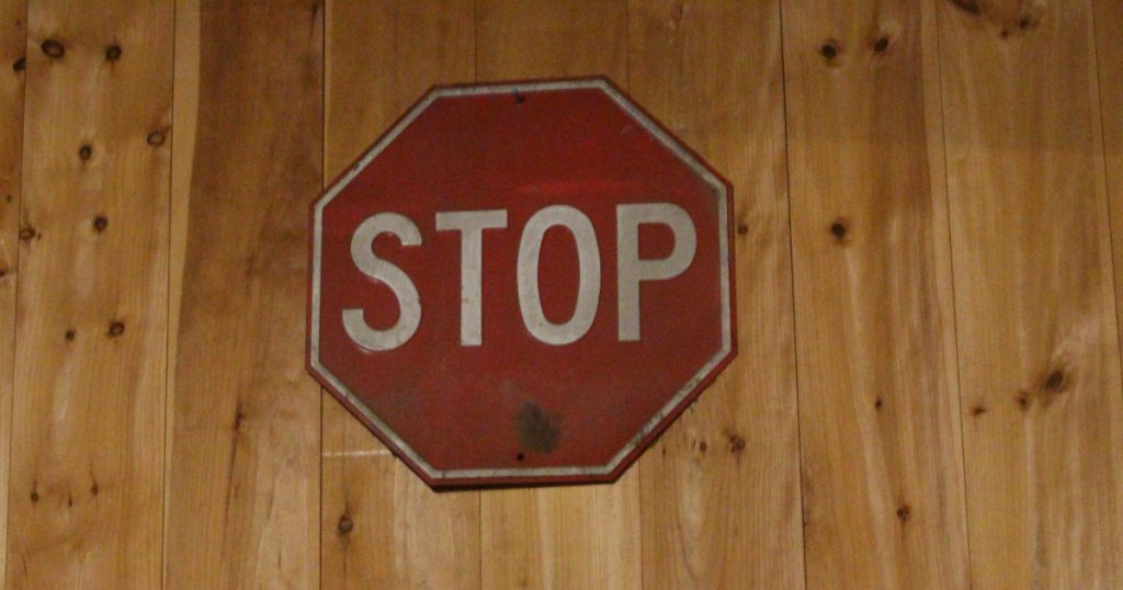 Red stop sign on a wooden wall