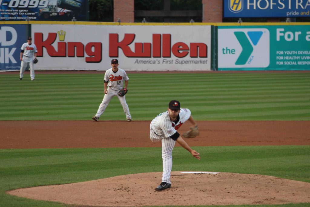 Baseball pitcher throwing from the mound during a minor league game