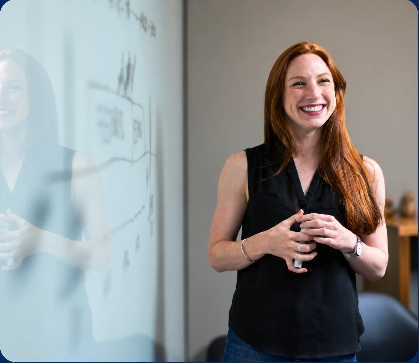 Smiling team member presenting at a whiteboard covered in charts